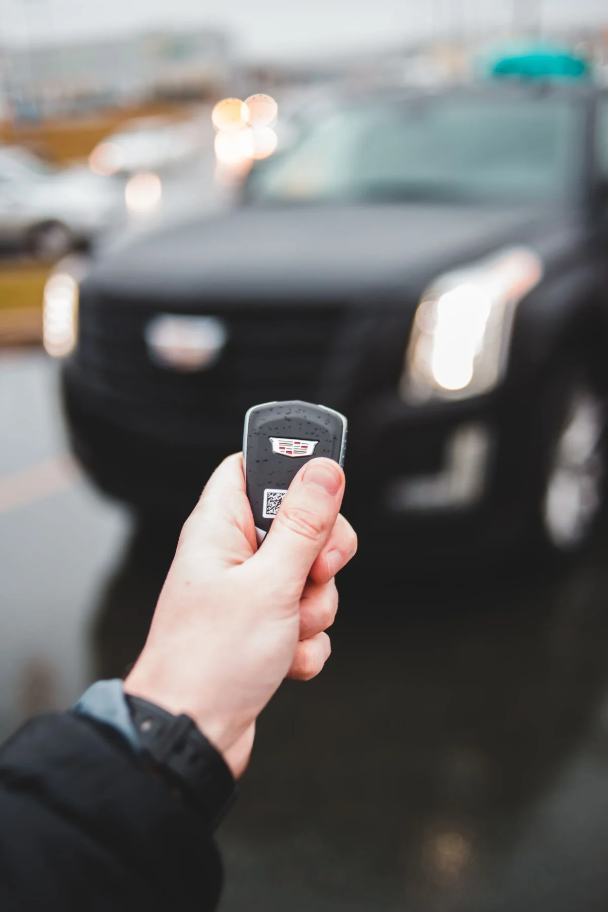 Llave de auto en primer plano frente a un vehículo estacionado